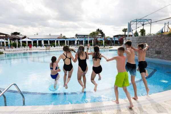 Gruppe von Jugendlichen springen in ein Aussenpool