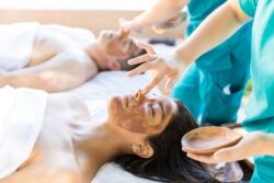 Mann und Frau bekommen Massage und Gesichtsbehandlung gleichzeitig